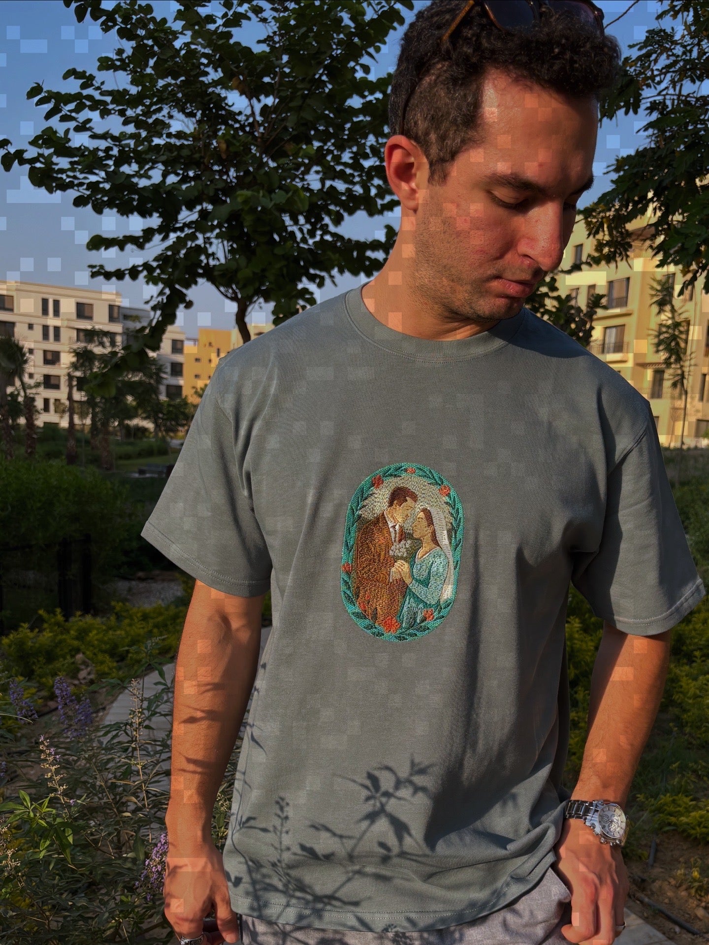 Man wearing a gray t-shirt with a graphic design outdoors