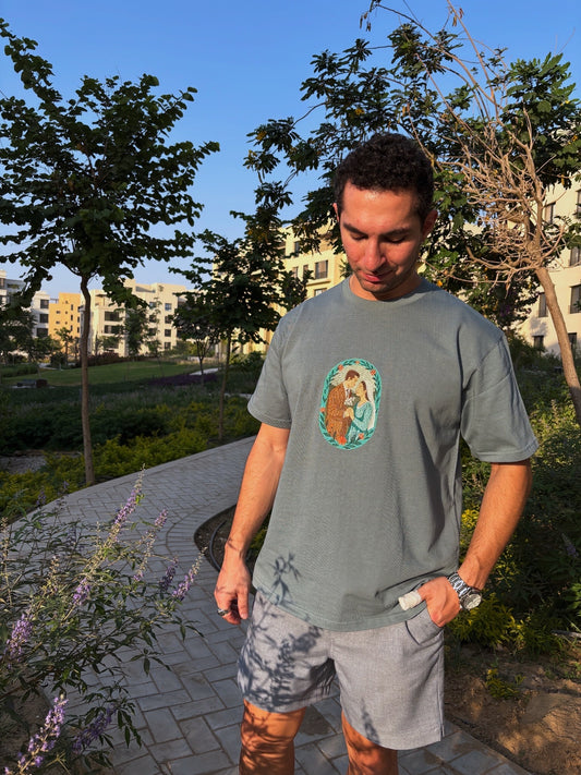 Man wearing a t-shirt with a graphic design in an outdoor setting