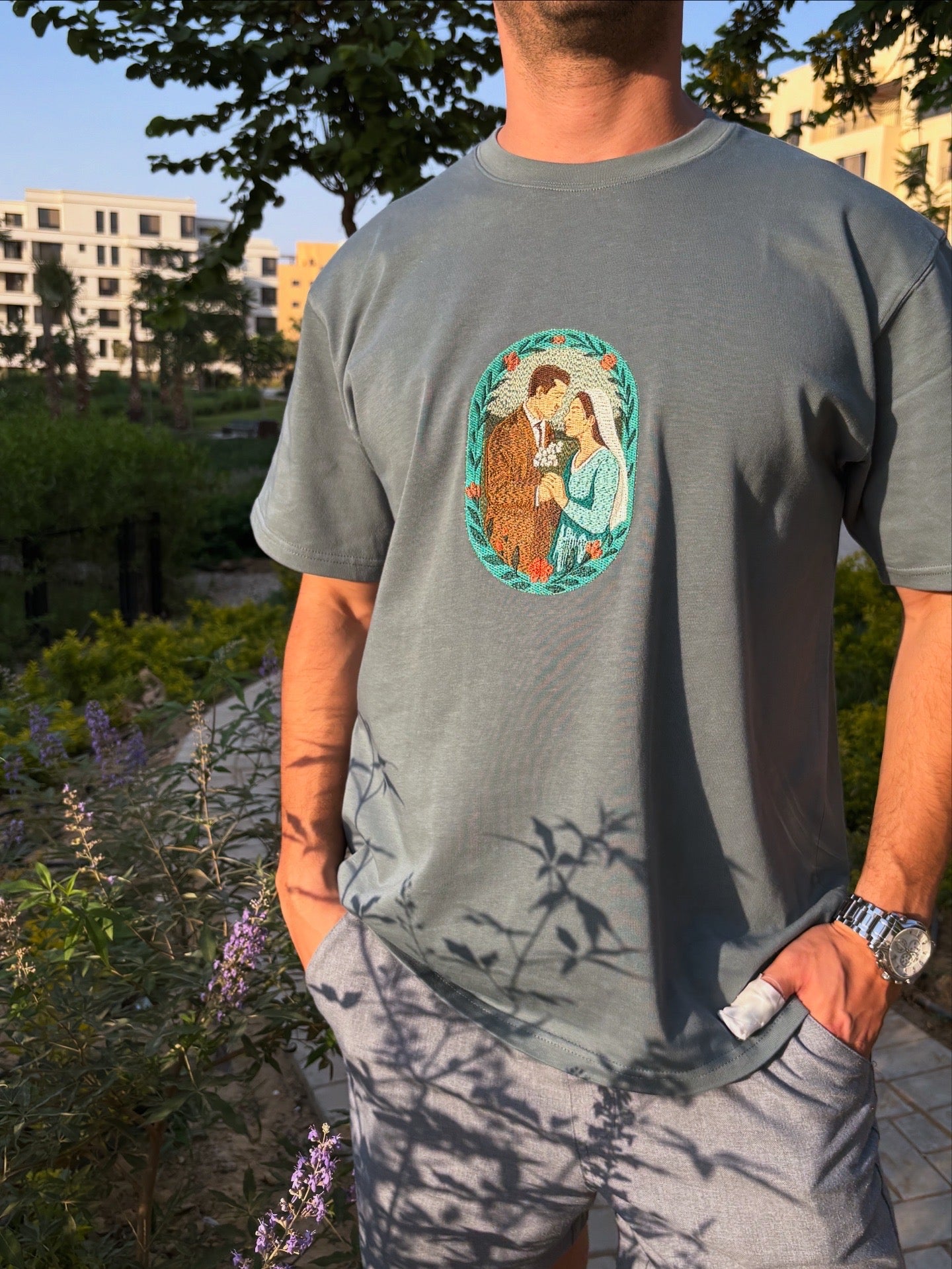 Person wearing a gray t-shirt with a graphic design outdoors