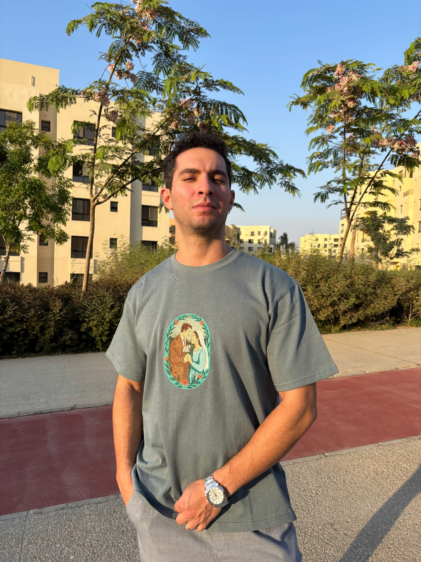 Man wearing a gray t-shirt with a graphic design outdoors